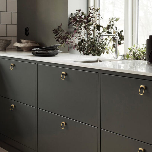 Rounded rectangle cabinet pull, shown in a focused view installed on cabinetry in context