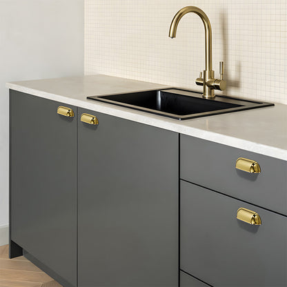 Polished gold retro shell cup pull and round knob, pictured in one view installed on cabinetry in context