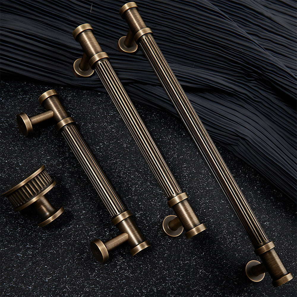 Ribbed bronze cabinet pull and round knob, shown clearly with related hardware in one display