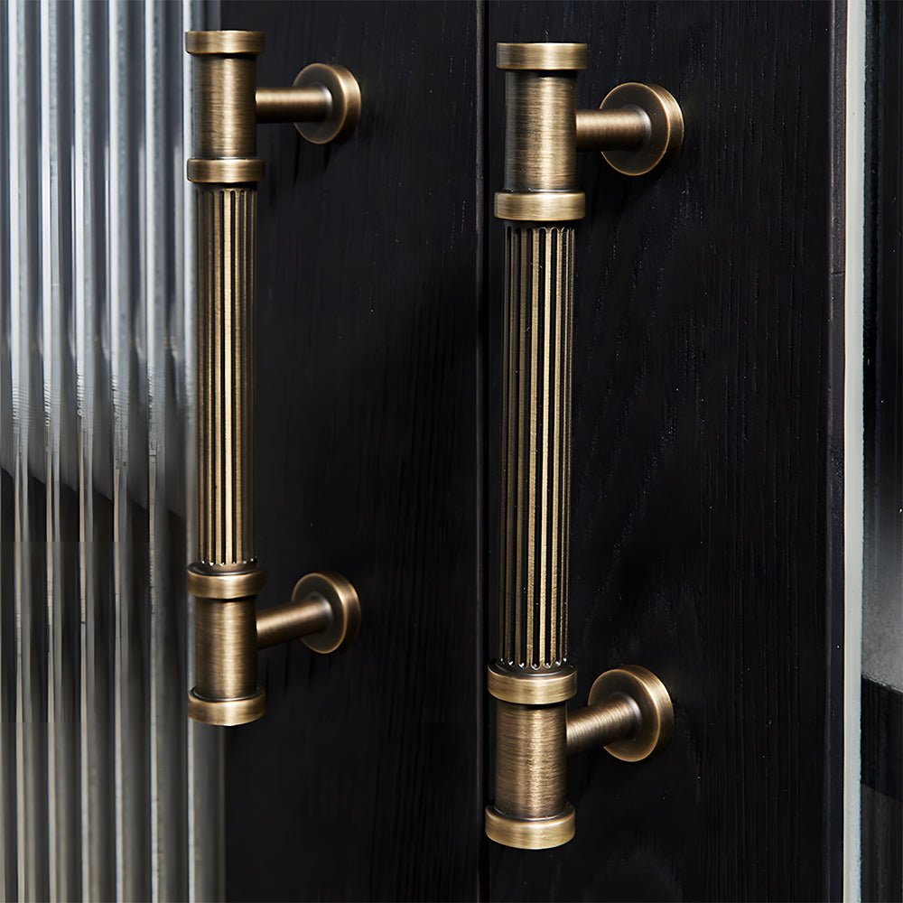 Ribbed bronze cabinet pull and round knob, shown clearly in an installed cabinet close-up