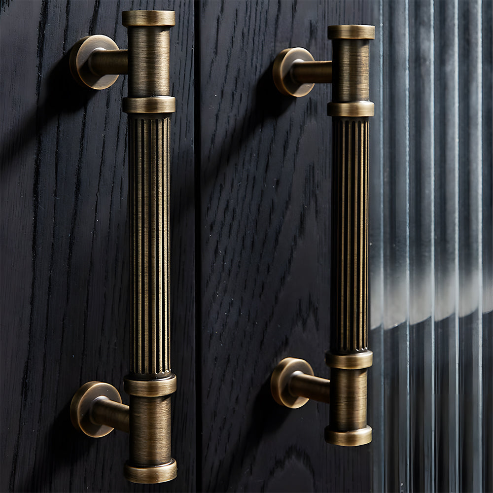 Ribbed bronze cabinet pull and round knob, shown from one angle in an installed cabinet close-up