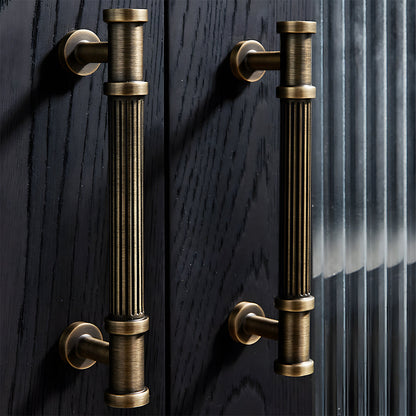 Ribbed bronze cabinet pull and round knob, shown from one angle in an installed cabinet close-up