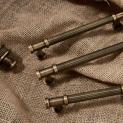 Ribbed bronze cabinet pull and round knob, presented for reference with related hardware in one display