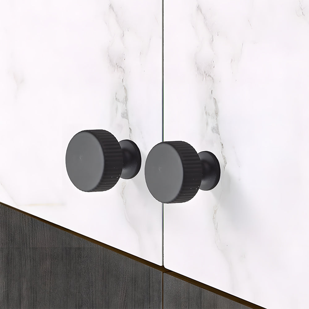 Black ribbed bar cabinet pull and round knob, presented for reference in an installed cabinet close-up