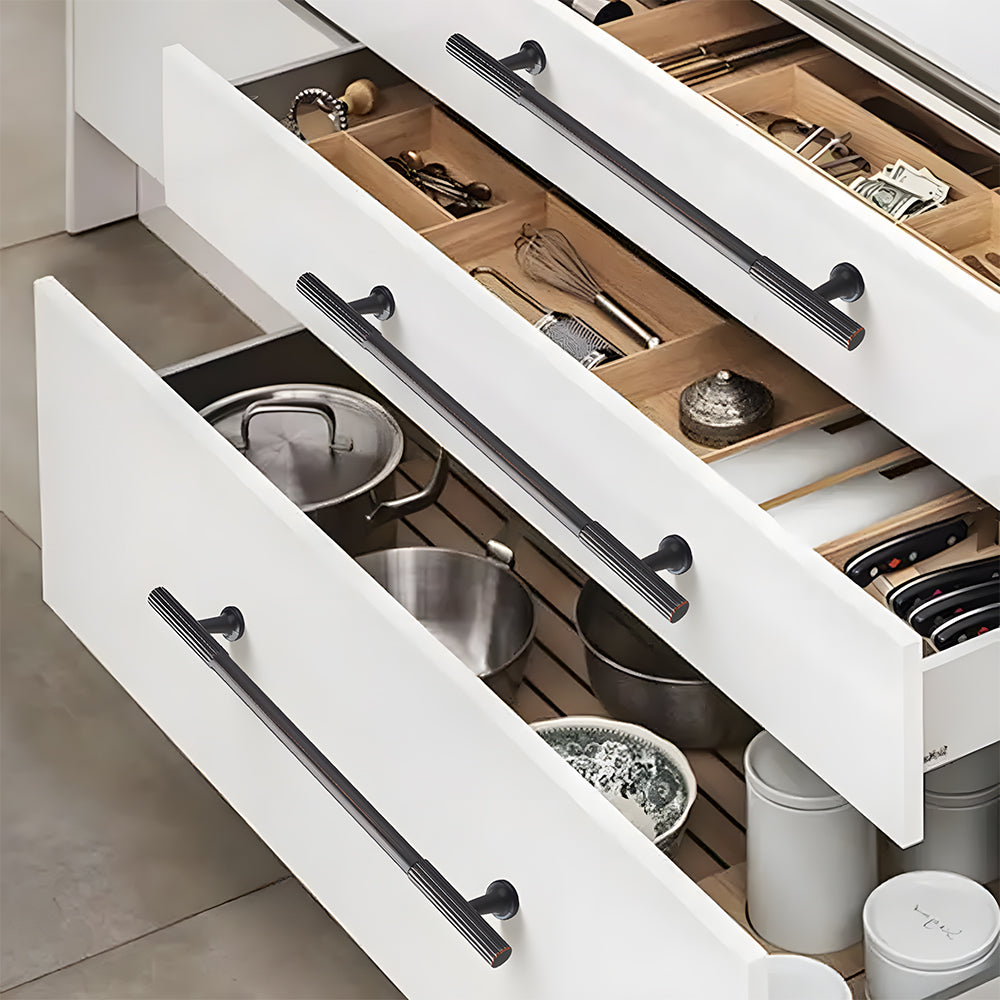 Bronze red ribbed bar cabinet pull and round knob, shown in a focused view mounted on a finished cabinet front
