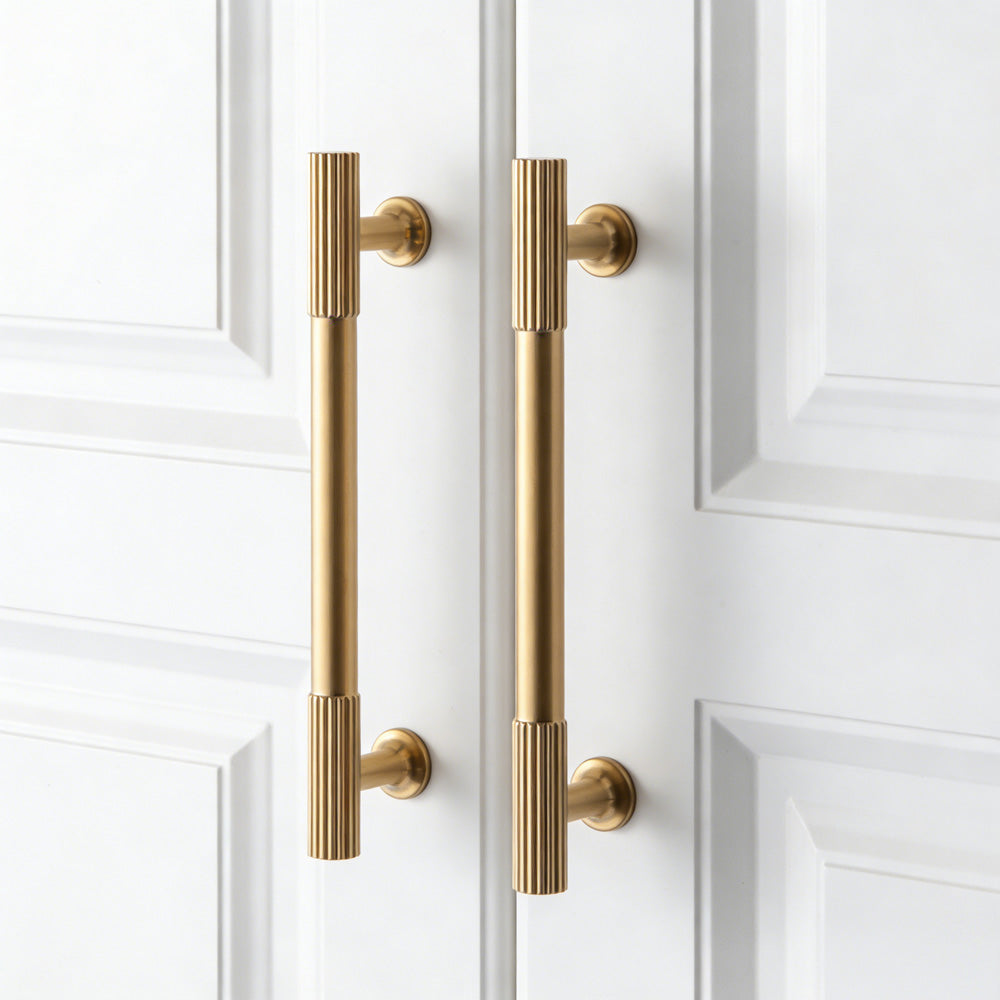 Matte gold ribbed bar cabinet pull and round knob, shown at close range with the finish and grip area visible