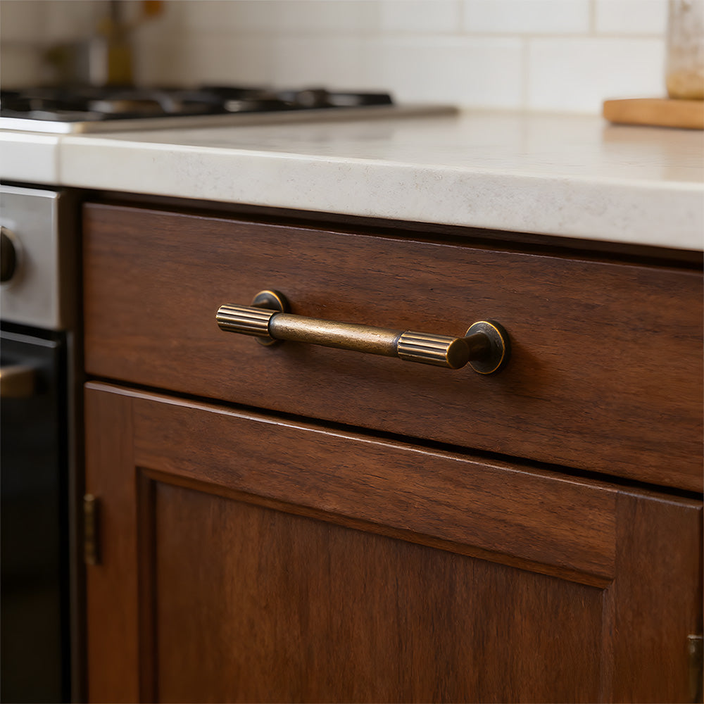 Antique bronze ribbed bar cabinet pull and round knob, shown in a focused view with the finish and grip area visible