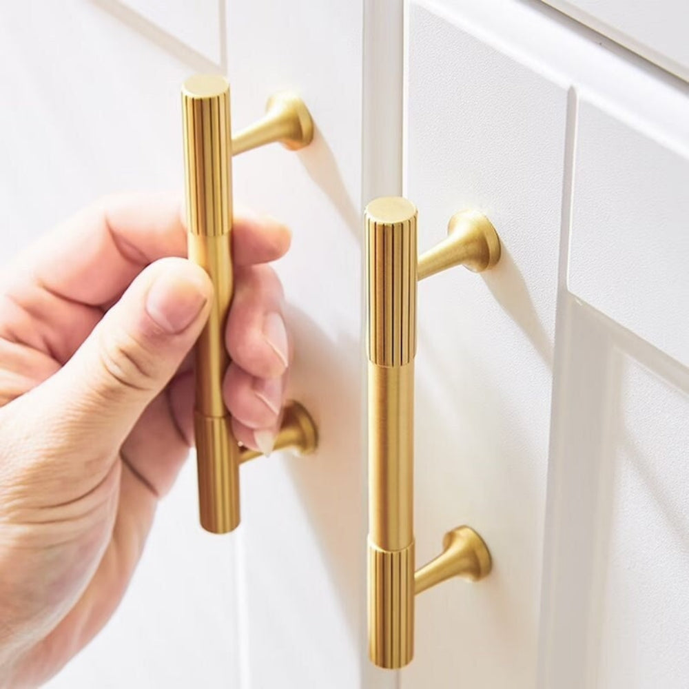 Ribbed bar cabinet pull and round knob, shown clearly while held or operated by hand