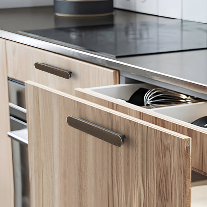 Bronze rounded-edge brass cabinet pull and round knob, presented for reference installed on cabinetry in context