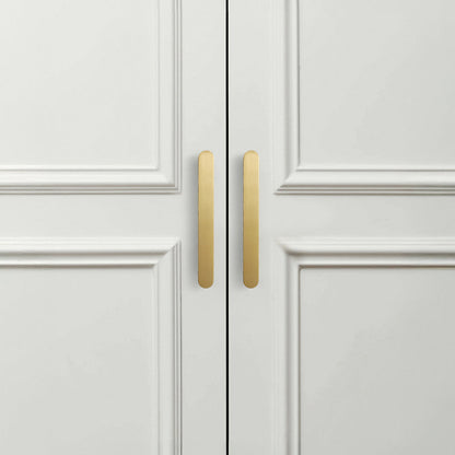 Gold rounded-edge brass cabinet pull and round knob, shown from one angle in an installed cabinet close-up