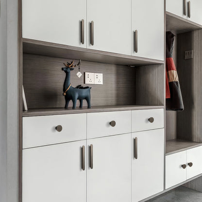 Bronze rounded-edge brass cabinet pull and round knob, shown in a focused view installed on cabinetry in context
