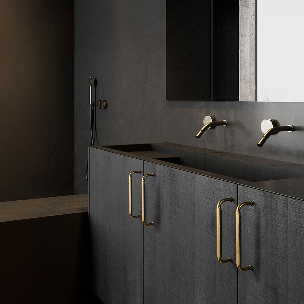 Smooth bronze cabinet pull with gently bent ends, presented in another view installed on cabinetry in context