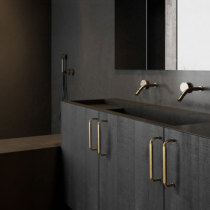 Smooth bronze cabinet pull with gently bent ends, presented in another view installed on cabinetry in context