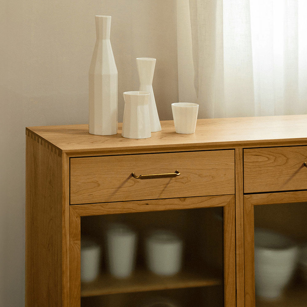 Smooth bronze cabinet pull with gently bent ends, presented for reference installed on cabinetry in context