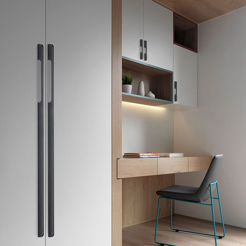 Extra-long matte black cabinet pulls installed vertically on tall wardrobe doors in a home office