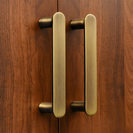 Bronze brass rounded bar cabinet pull, shown clearly installed on cabinetry in context