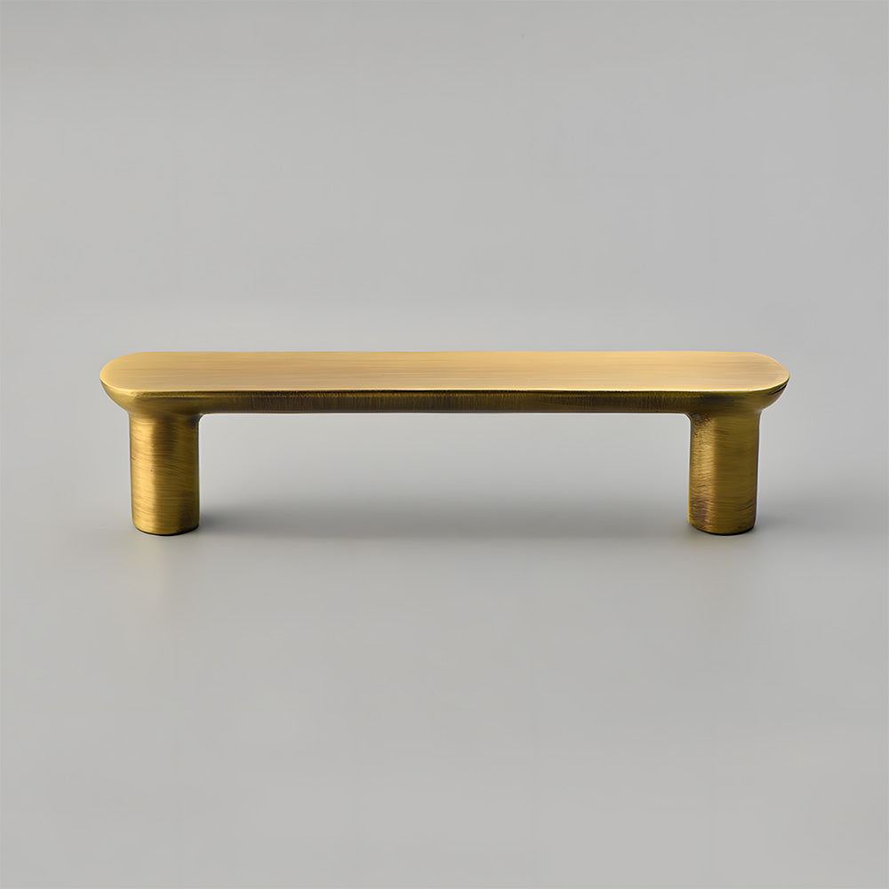 Brass rounded bar cabinet pull, shown from one angle on a clean neutral background