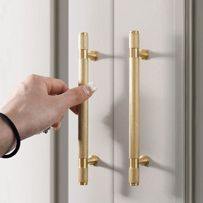 Gold knurled brass T-bar cabinet pull, shown clearly while held or operated by hand