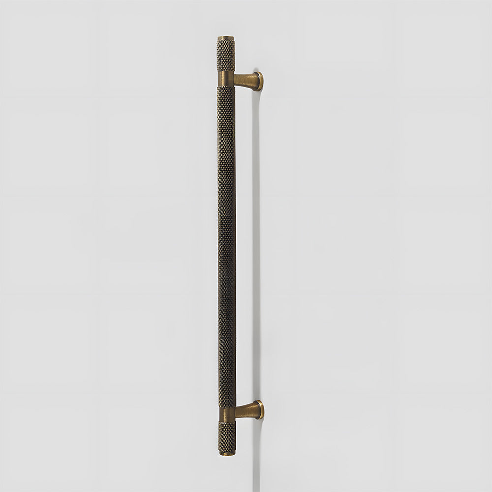 Knurled brass T-bar cabinet pull, shown at close range on a clean neutral background