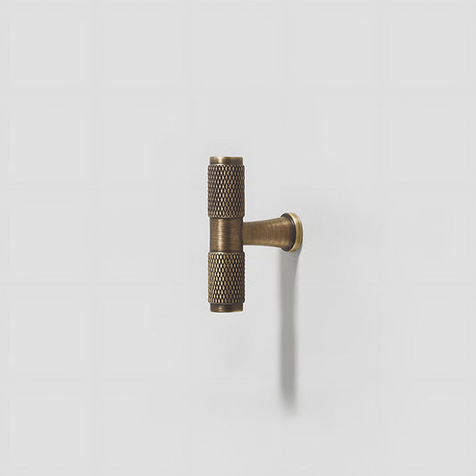 Antique bronze knurled brass T-bar cabinet pull, displayed from the side on a clean neutral background