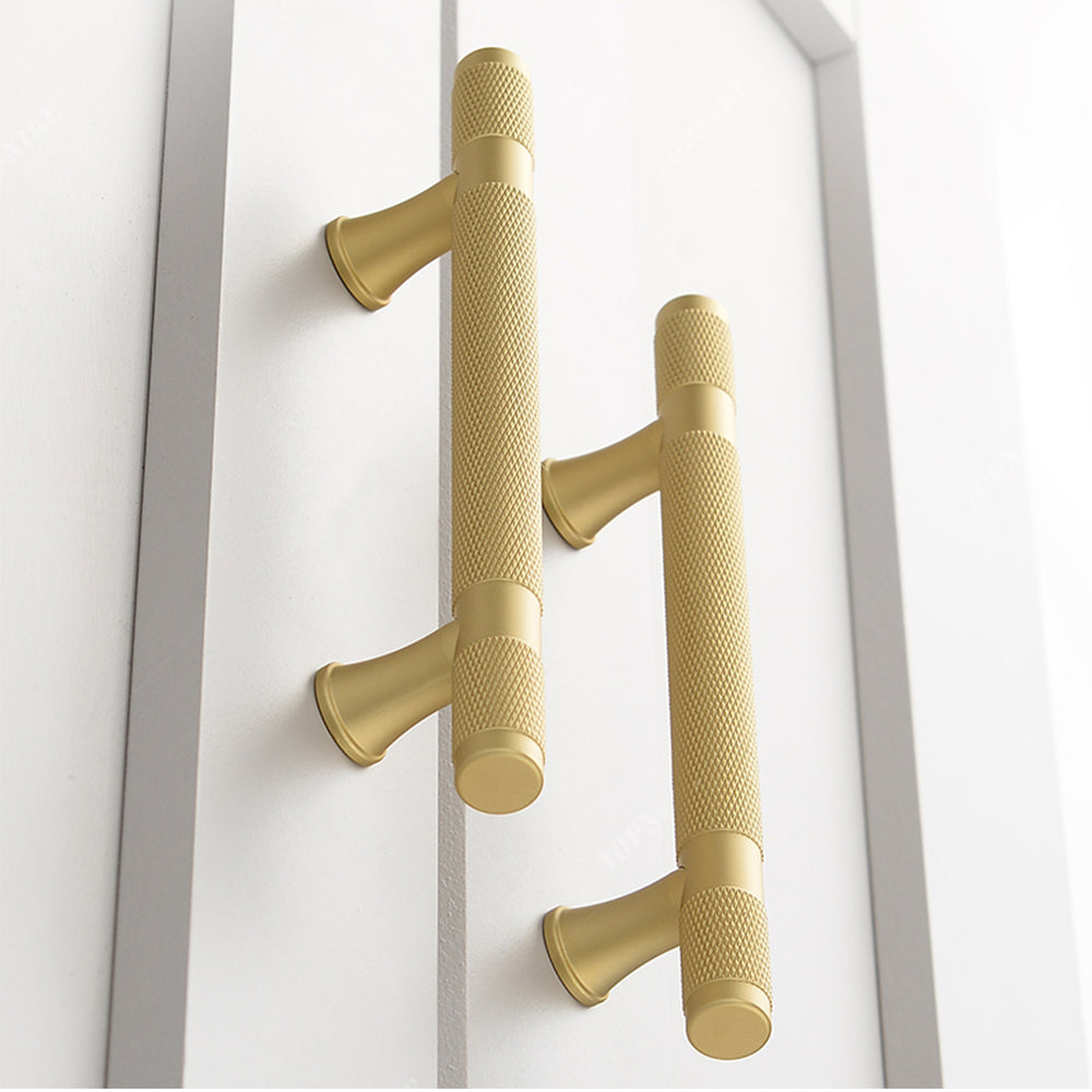 Gold knurled brass T-bar cabinet pull, shown from one angle in an installed cabinet close-up