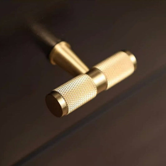 Gold knurled brass T-bar cabinet pull, pictured in one view in an installed cabinet close-up