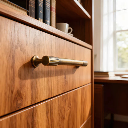 Brass textured cabinet pull, shown from one angle in an installed cabinet close-up