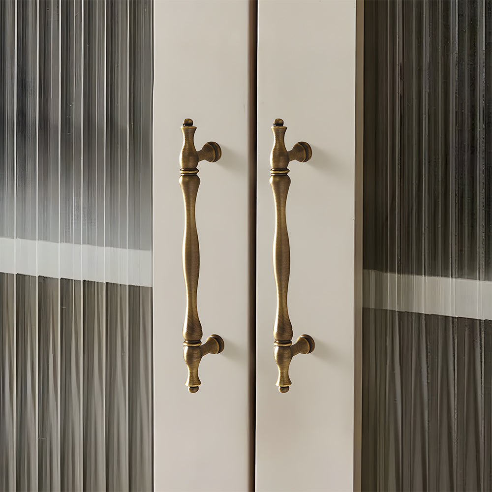 Bronze brass twisted cabinet pull and knobs, shown in a focused view mounted on a finished cabinet front