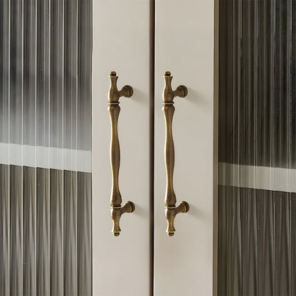 Bronze brass twisted cabinet pull and knobs, shown in a focused view mounted on a finished cabinet front
