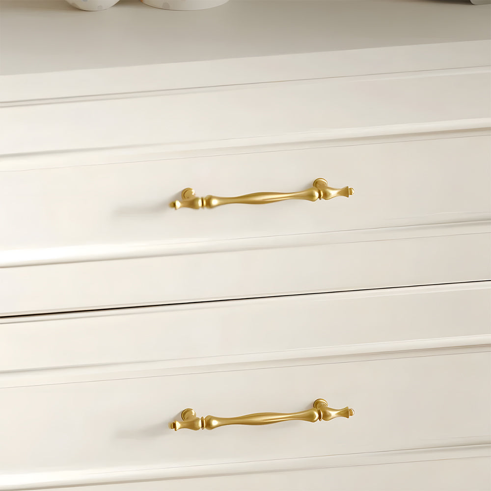 Gold brass twisted cabinet pull and knobs, pictured in one view installed on cabinetry in context