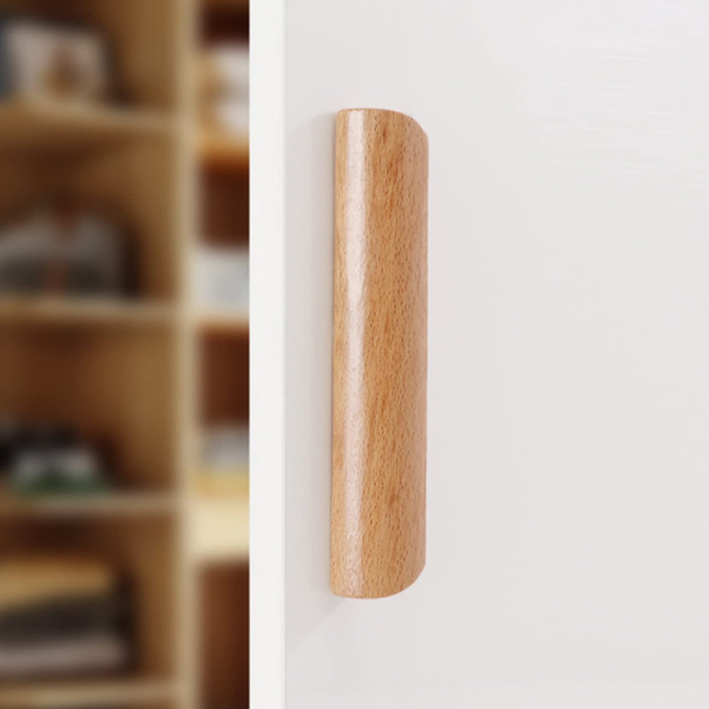 Solid beech wood half-round cabinet finger pull, installed on paired cabinet doors in a close view