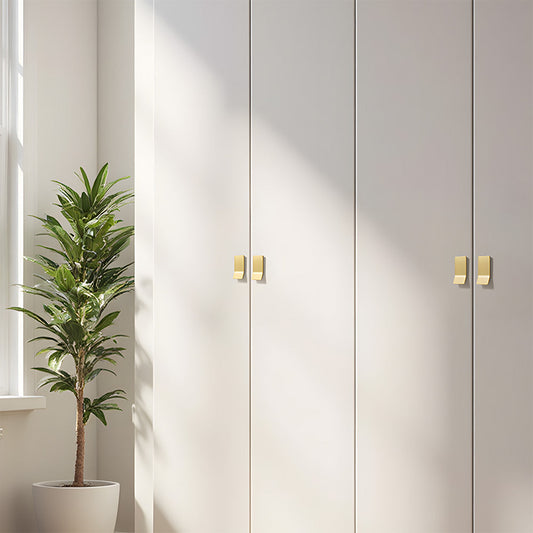 Gold square finger edge pull with a curved grip, shown clearly installed on cabinetry in context