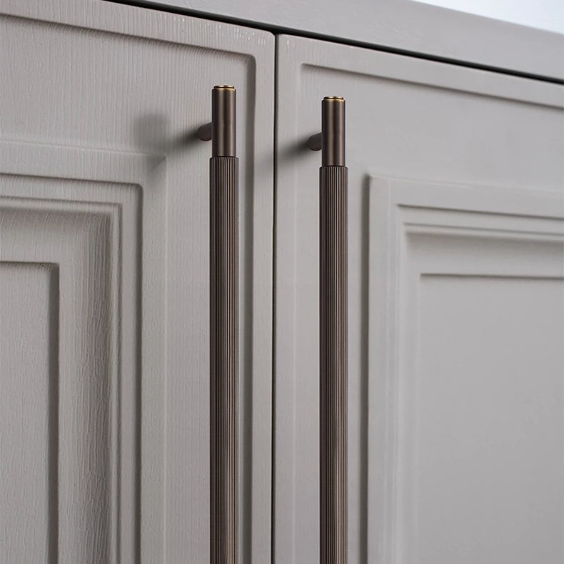 Striped T-bar cabinet pull, shown clearly in an installed cabinet close-up with key hardware details visible