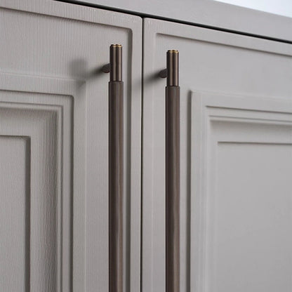 Striped T-bar cabinet pull, shown clearly in an installed cabinet close-up with key hardware details visible