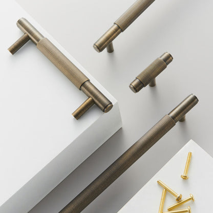 Striped T-bar cabinet pull, shown from one angle with related hardware in one display