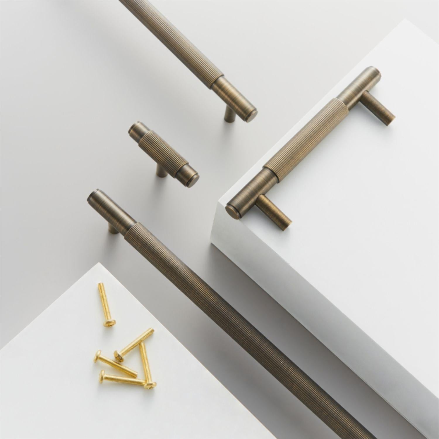 Striped T-bar cabinet pull, pictured in one view with related hardware in one display