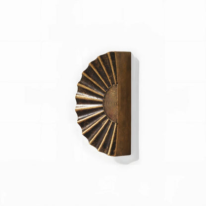 Sunburst half-moon cabinet pull and round knob, presented for reference on a clean neutral background