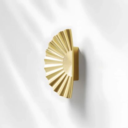 Sunburst half-moon cabinet pull and round knob, shown at close range on a clean neutral background