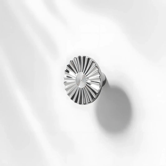 Silver sunburst half-moon cabinet pull and round knob, shown clearly with its shape and finish visible