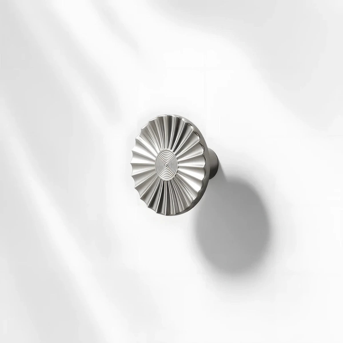 Sunburst half-moon cabinet pull and round knob, presented for reference with its shape and finish visible