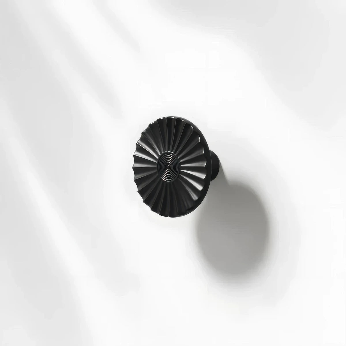 Black sunburst half-moon cabinet pull and round knob, presented for reference with the profile and mounts in view