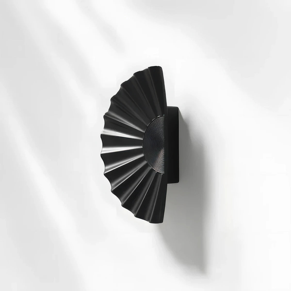 Black sunburst half-moon cabinet pull and round knob, shown at close range with the profile and mounts in view