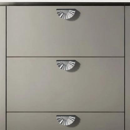 Silver sunburst half-moon cabinet pull and round knob, presented for reference installed on cabinetry in context