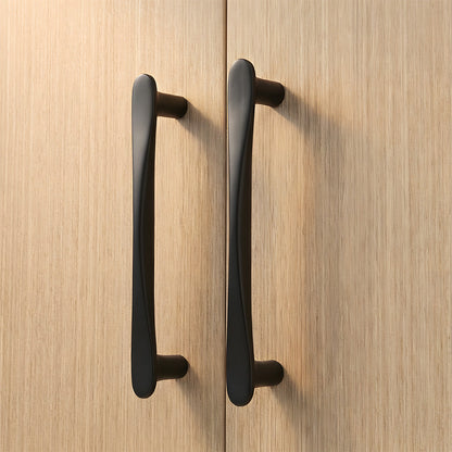 Black tapered arched brass cabinet pull, shown at close range in an installed cabinet close-up