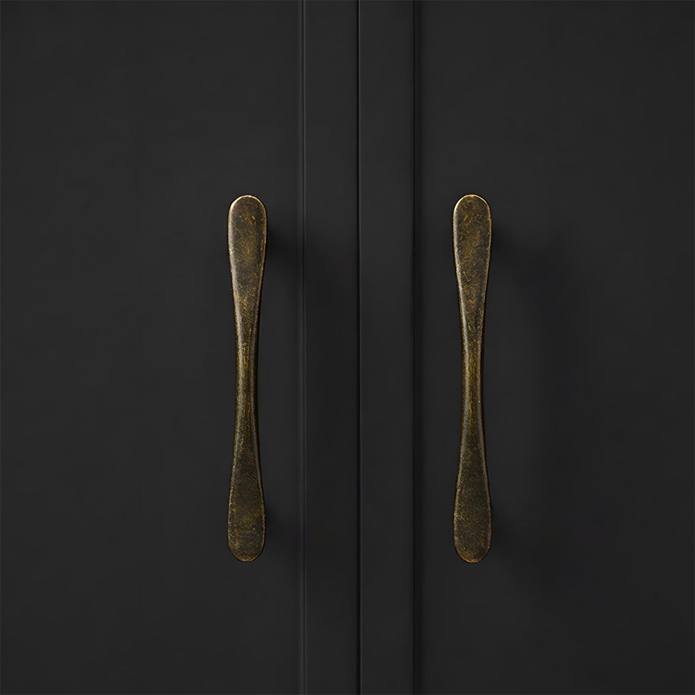 Antique bronze tapered arched brass cabinet pull, shown clearly in an installed cabinet close-up