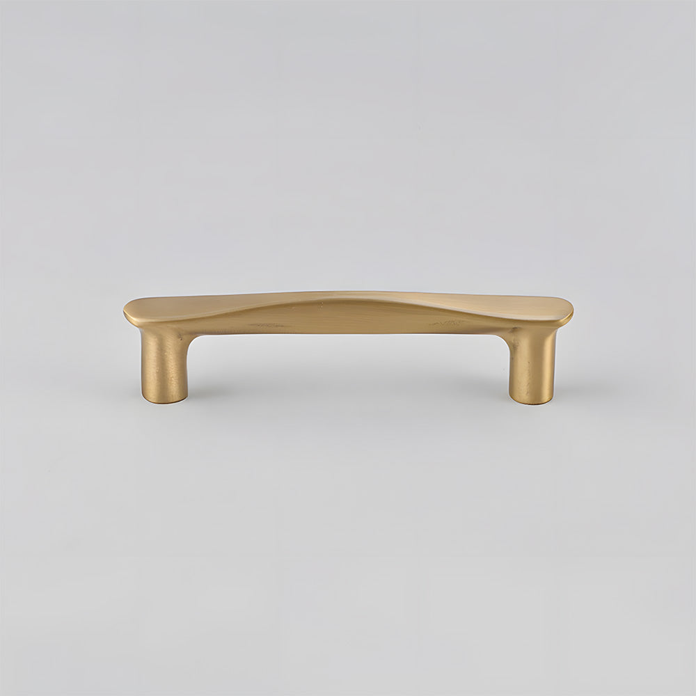 Tapered arched brass cabinet pull, shown from one angle on a clean neutral background