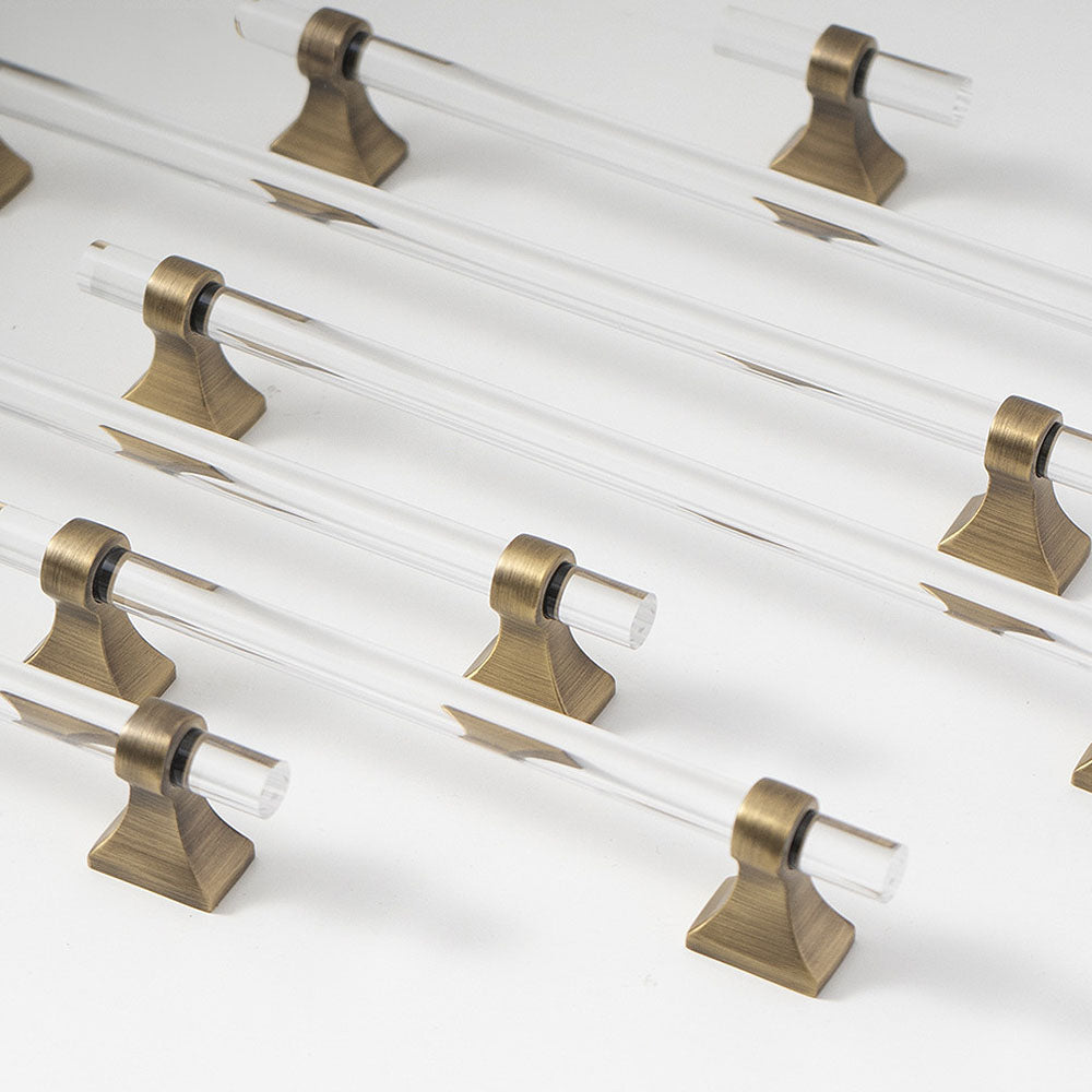 Transparent acrylic bar pull with flared metal mounts, displayed from the side as a color and finish lineup