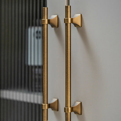 Vintage round bar cabinet pull with pedestal mounts, shown clearly in an installed cabinet close-up