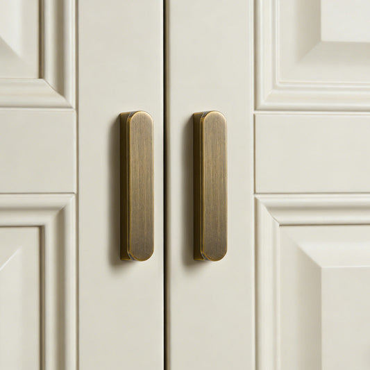 Vintage bronze brass cabinet pull, shown in a focused view in an installed cabinet close-up