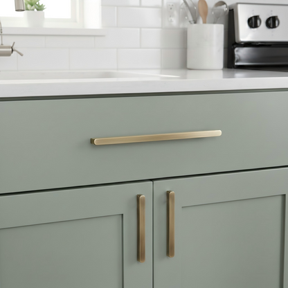 Vintage bronze brass cabinet pull, shown from one angle installed on cabinetry in context